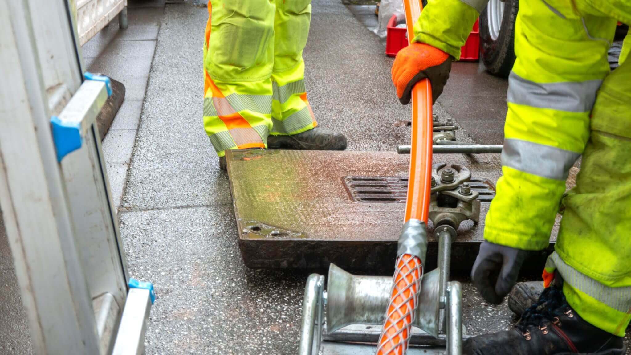 Construction workers handling orange cable